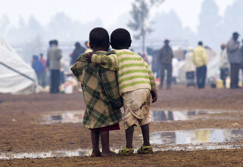 Two children stand together during heavy rainfall in a displaced persons camp in Kenya's Rift Valley