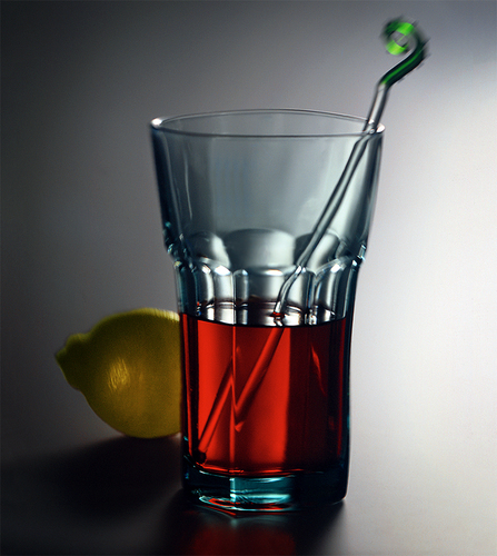 Glass with red and lemon on table