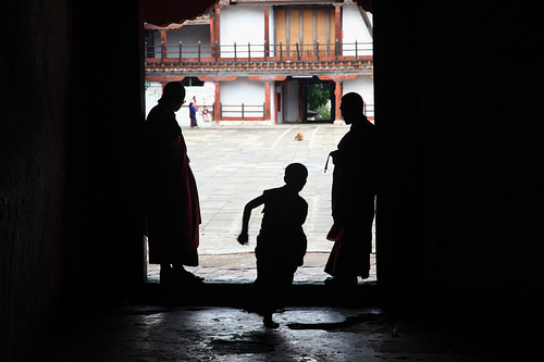 Young Monk Scurrying Past His Superiors. Bhutan Young Monk Scurrying Past His Superiors. Bhutan