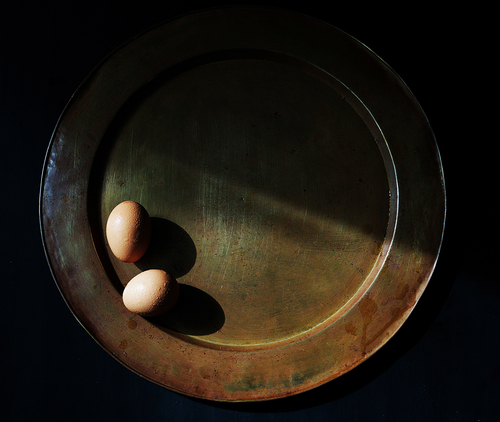 A brass tray and two eggs