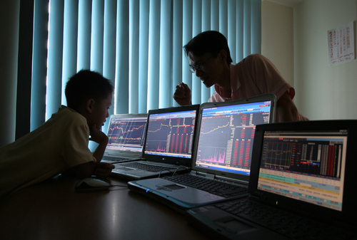 father teaches his 6-year-old boy about stock market