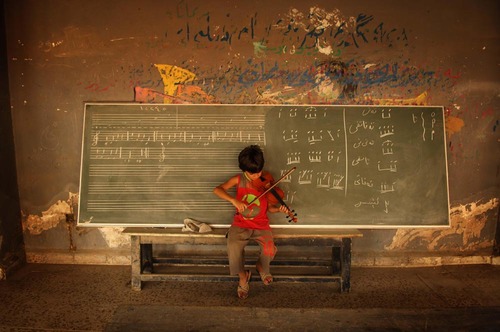 A boy plays the violin at Sulaimaniya Music Institute in Iraq