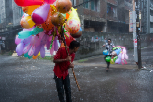 Balloon sellers running to take cover from the monsoon rain