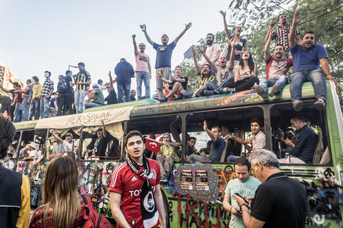 People chanting on top of a seized bus used as a barricade