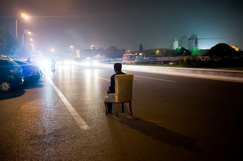 Man in Gold Chair on Road