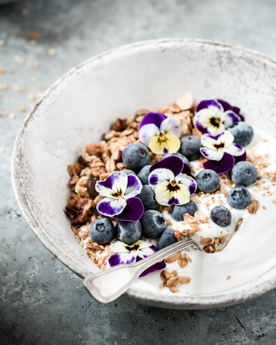 Yogurht with blueberries and pansies